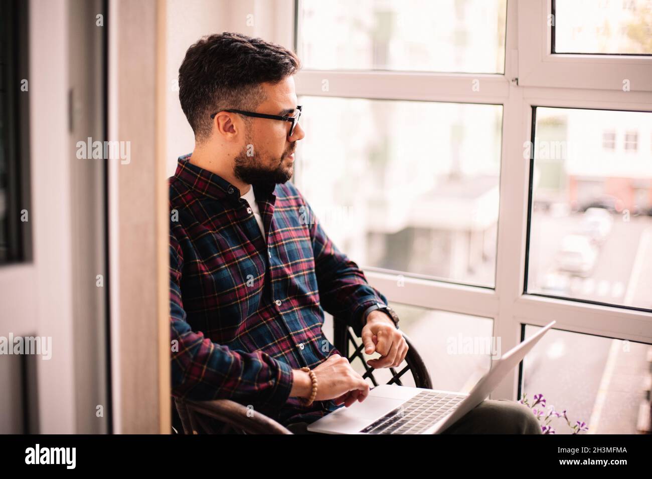 Serious thoughtful man using laptop computer at home Stock Photo
