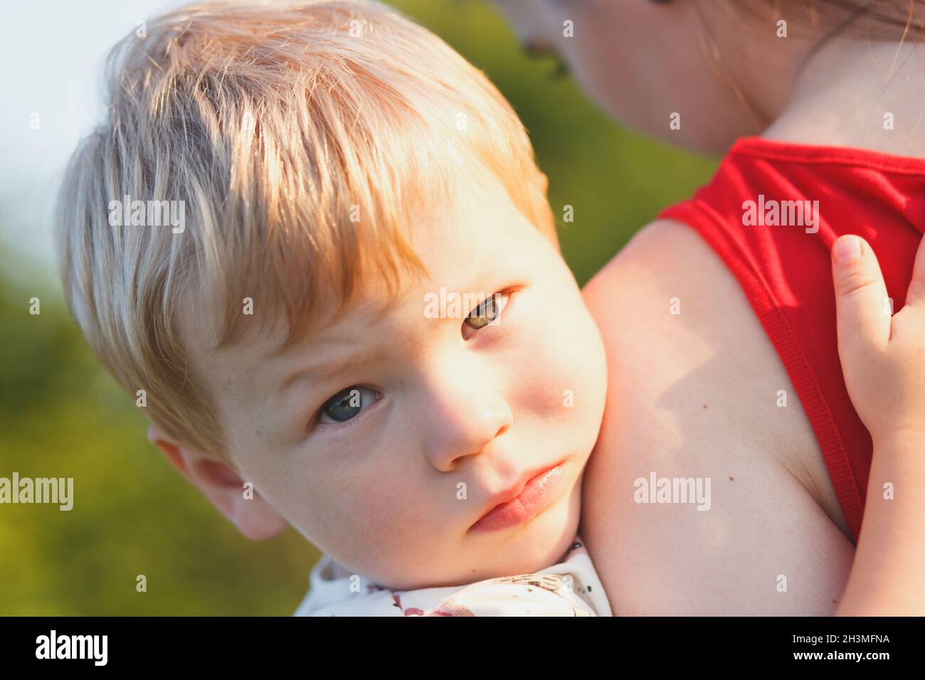 Portrait of a boy 2 years old in the arms of his mother Stock Photo