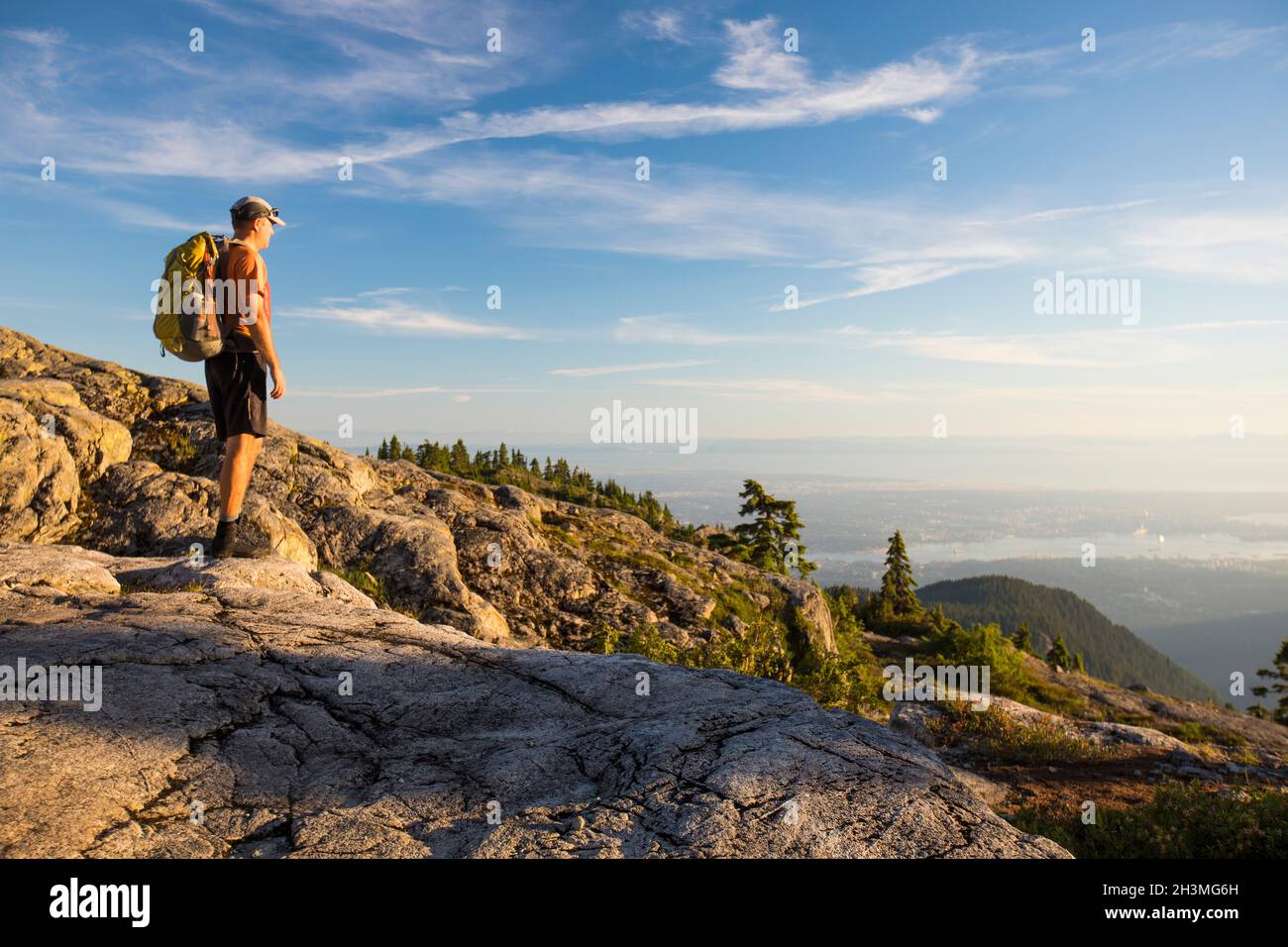 Man stands on Seymour Mountain looking down on Vancouver. Stock Photo