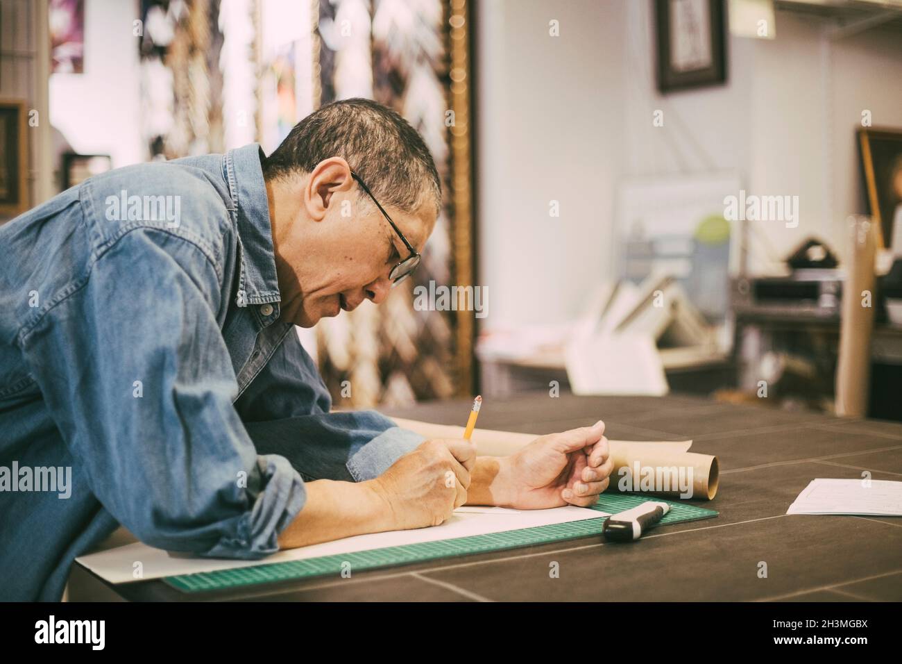 Male entrepreneur leaning while working at table in office Stock Photo