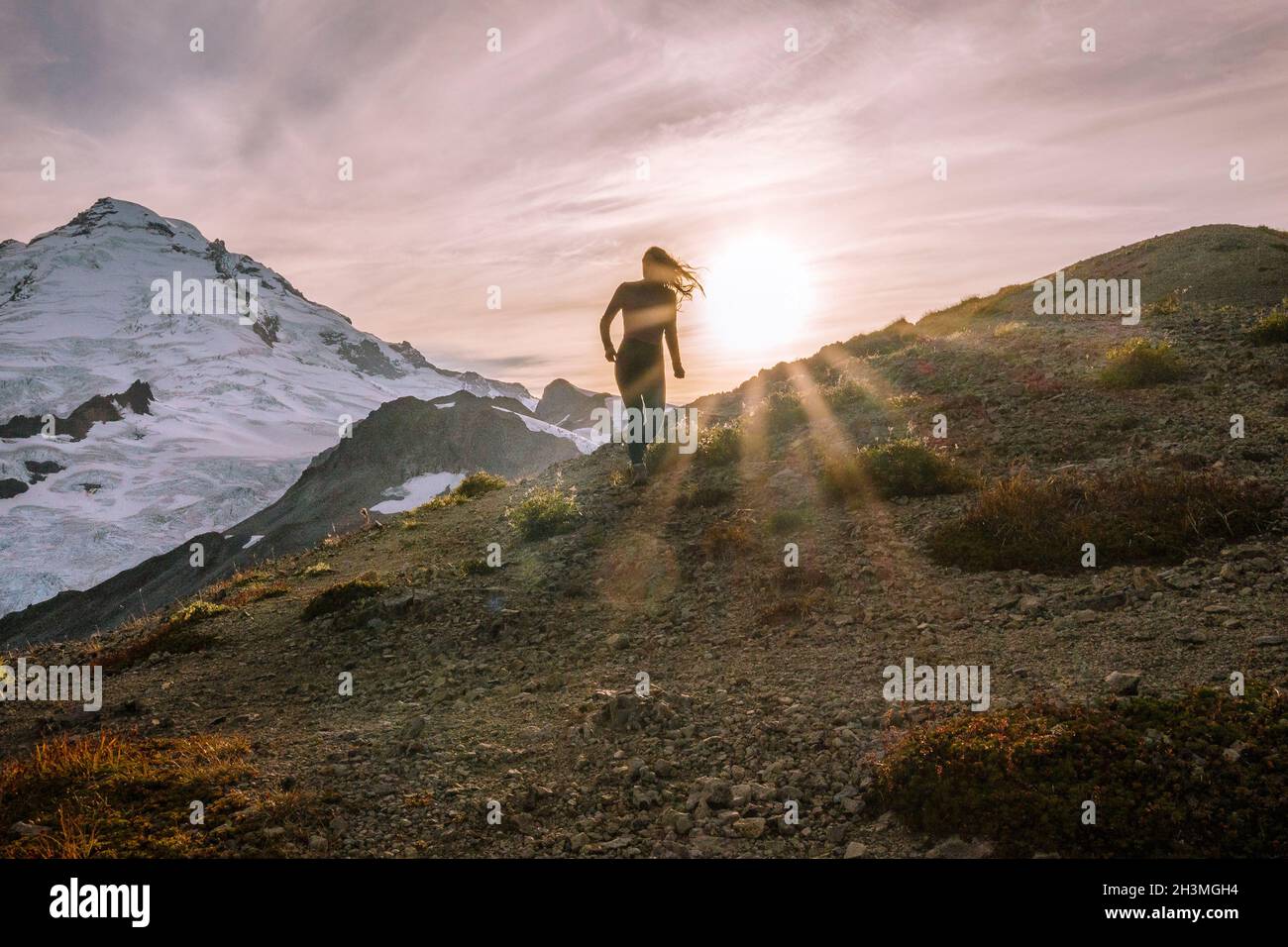 Silhouette of Female Hiking In Tights In Front Of Mount Baker Stock Photo