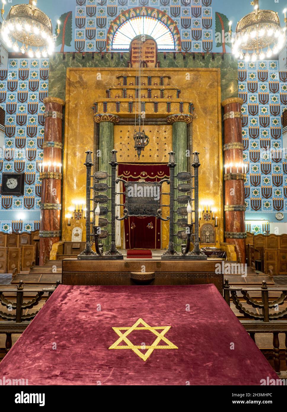 Front of the Kazinczy Orthodox Synagogue: The highly decorated front of this ancient synagogue including the eternal light, candelabra, bimah and ark. A carpeted platform with a star of David is in the foreground. Stock Photo