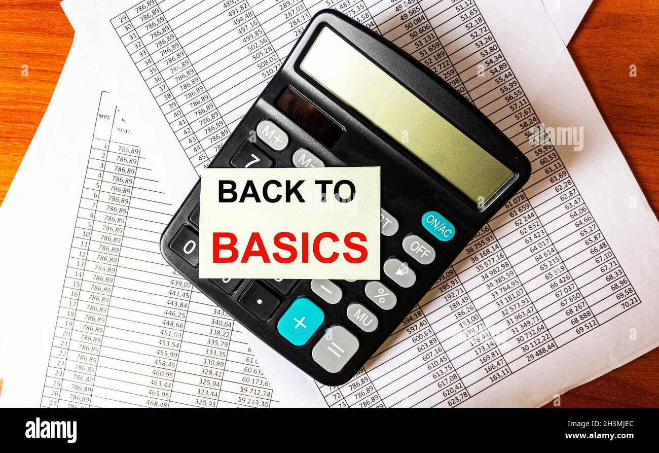 The phrase BACK TO BASICS on the sticker on the calculator and on documents with numbers Stock Photo