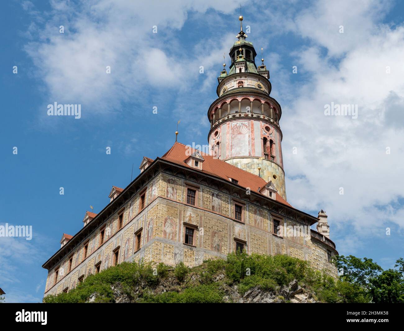 Český Krumlov Castle Tower from the hill below: This high round renaissance tower dominates the skyline in the small town of Český Krumlov. Fresco paintings decorate its facade. Stock Photo