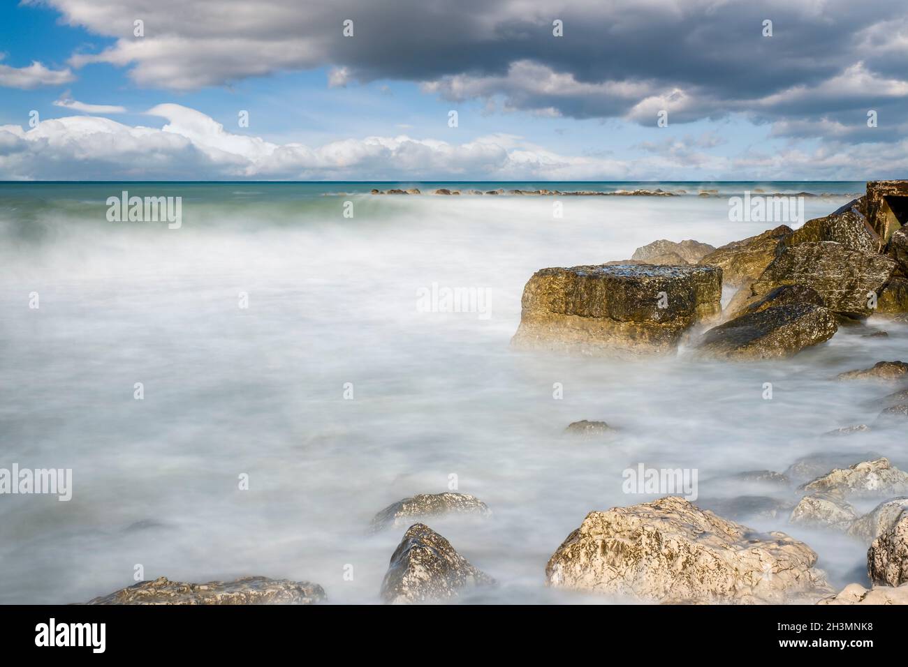 Cliffs in Adriatic sea. The sun's rays reflecting on the rocks. Long exposure. Stock Photo