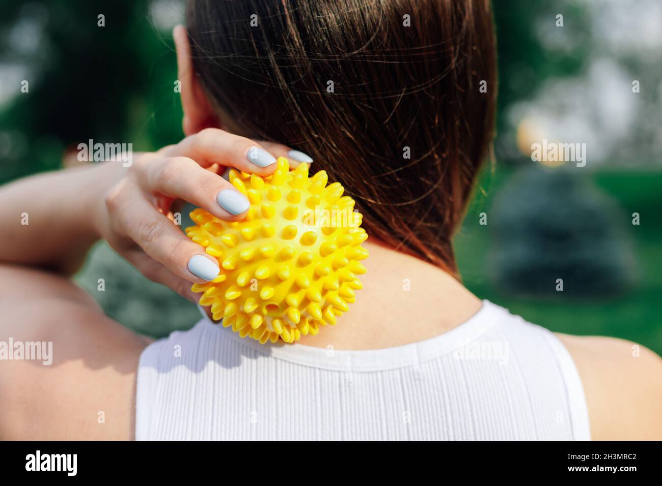 Young woman massage back with spiky trigger point ball, muscle pain treatment reflexology. Physiotherapy concept Stock Photo