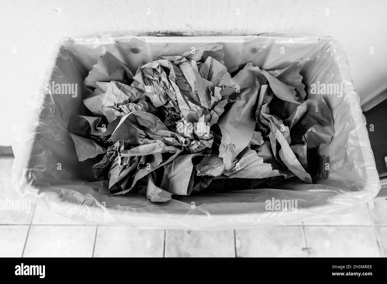 Crumpled brown paper towels in a trash can after being used to dry hands Stock Photo