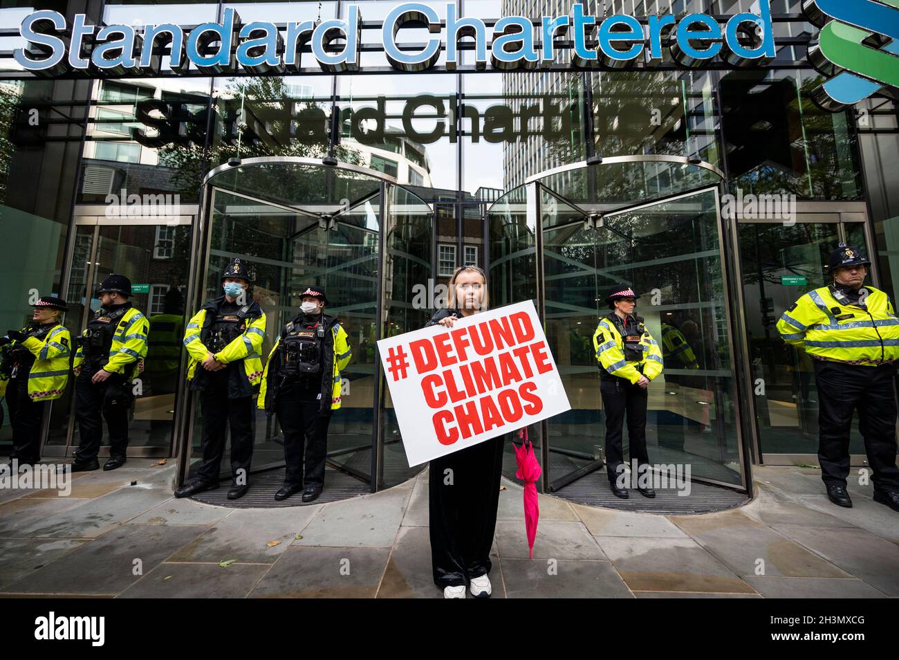 London, UK.  29 October 2021.  A youth climate activist protests outside Standard Chartered in the City of London to demand a stop to funding fossil fuels. The bank is reported to have financed US$31.4bn to the fossil fuel sector since the Paris Agreement was signed.  The protest is part of the wider Defund Climate Chaos campaign and comes as the UN Climate Change Conference of the Parties (COP26) takes place in Glasgow. Credit: Stephen Chung / Alamy Live News Stock Photo