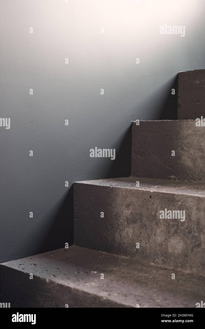 Close up of staircase on black stone wall corner background. Black lobby interior rough concrete stairway with black steel handrail. Minimalist Stock Photo
