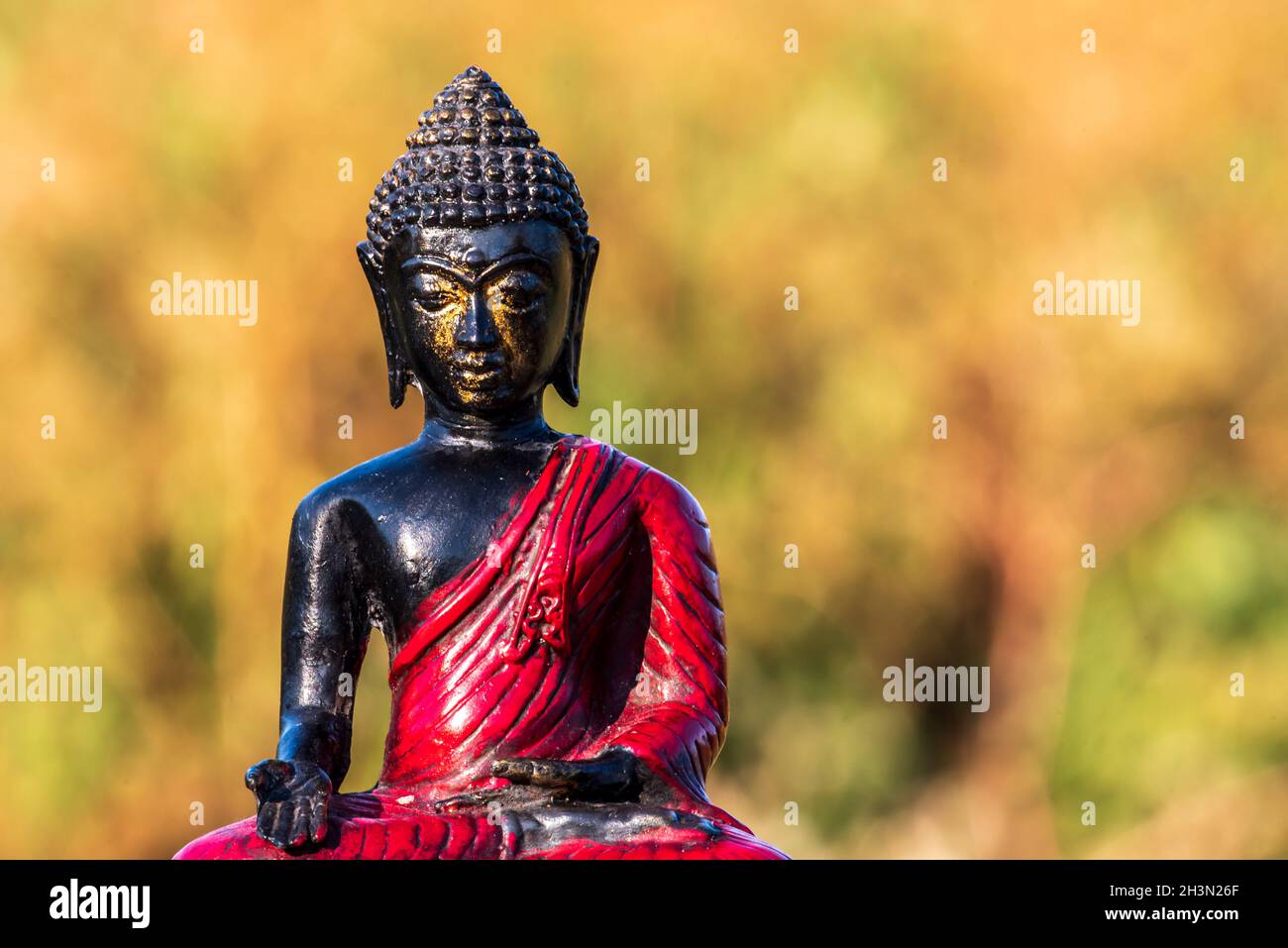 Little buddha figure in the morning sun Stock Photo Alamy