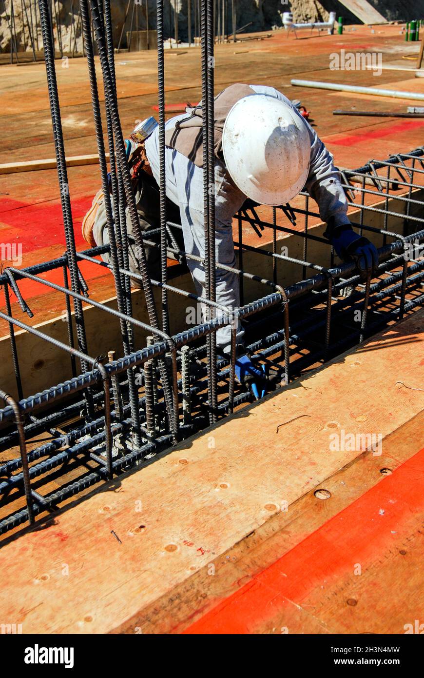 Concrete mason tying rebar on a new grade beam Stock Photo Alamy