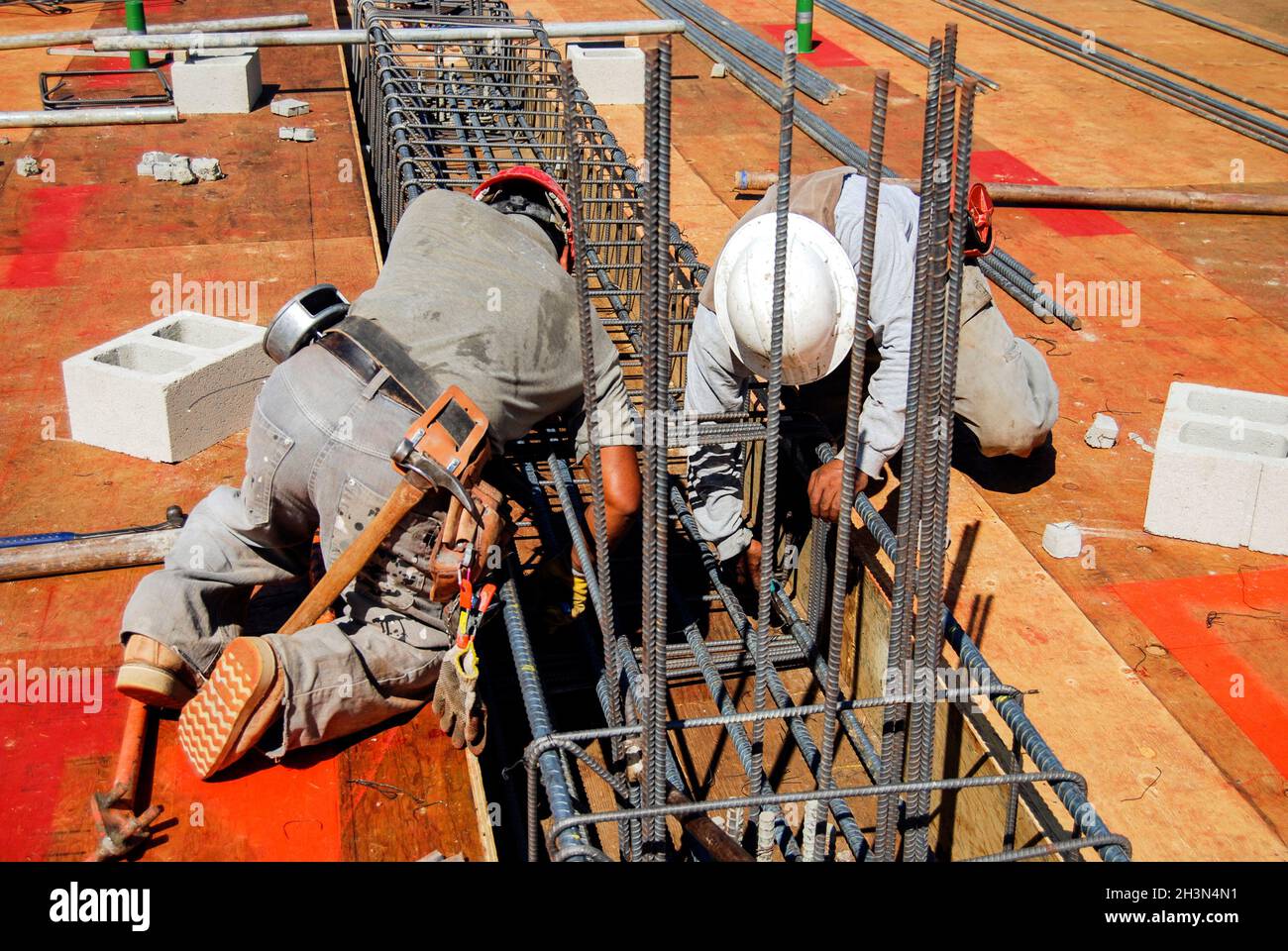 Two masons tying rebar on a new grade beam Stock Photo Alamy