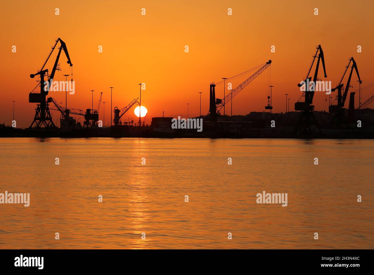 Cranes in port at sunrise Stock Photo
