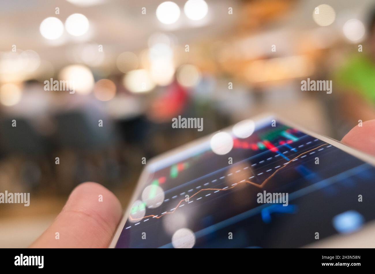Using a mobile device to check market data Stock Photo