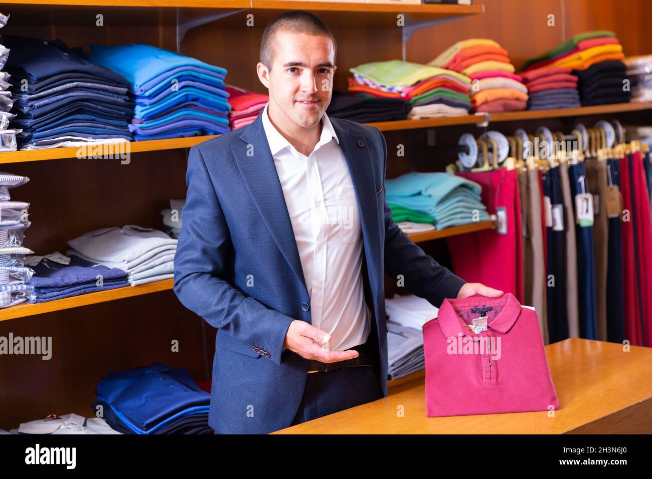 Picture of Young salesman offering stylish polo shirt Stock Photo - Alamy