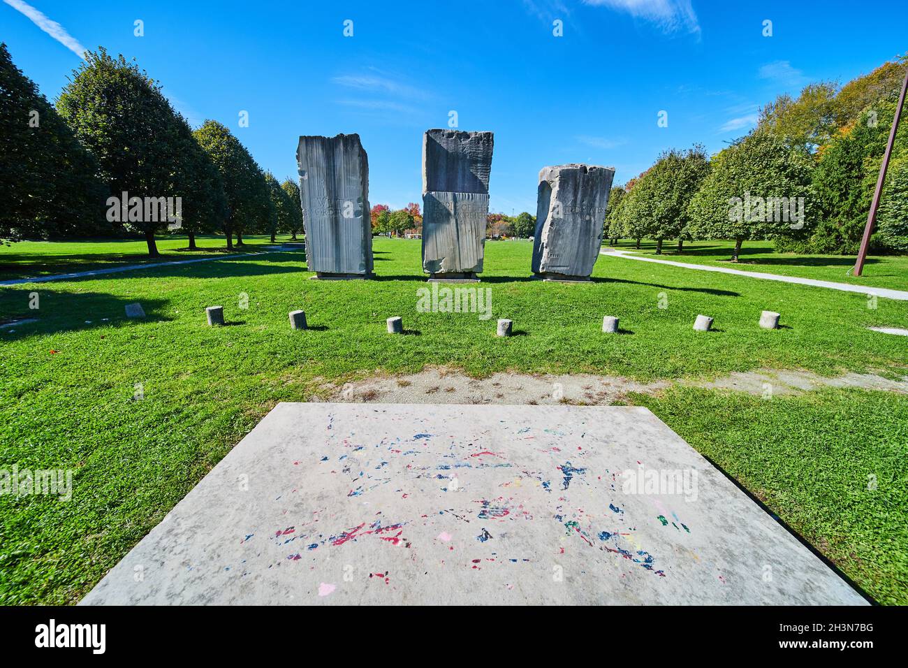 Open grass field with three large stone obelisk monuments Stock Photo
