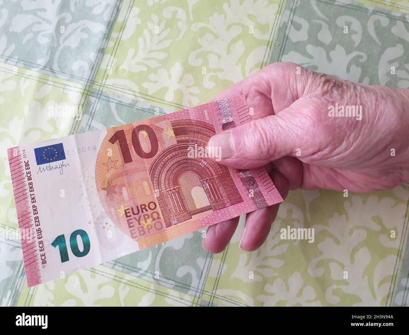 Alte Frau bezahlt mit einem Geldschein Stock Photo