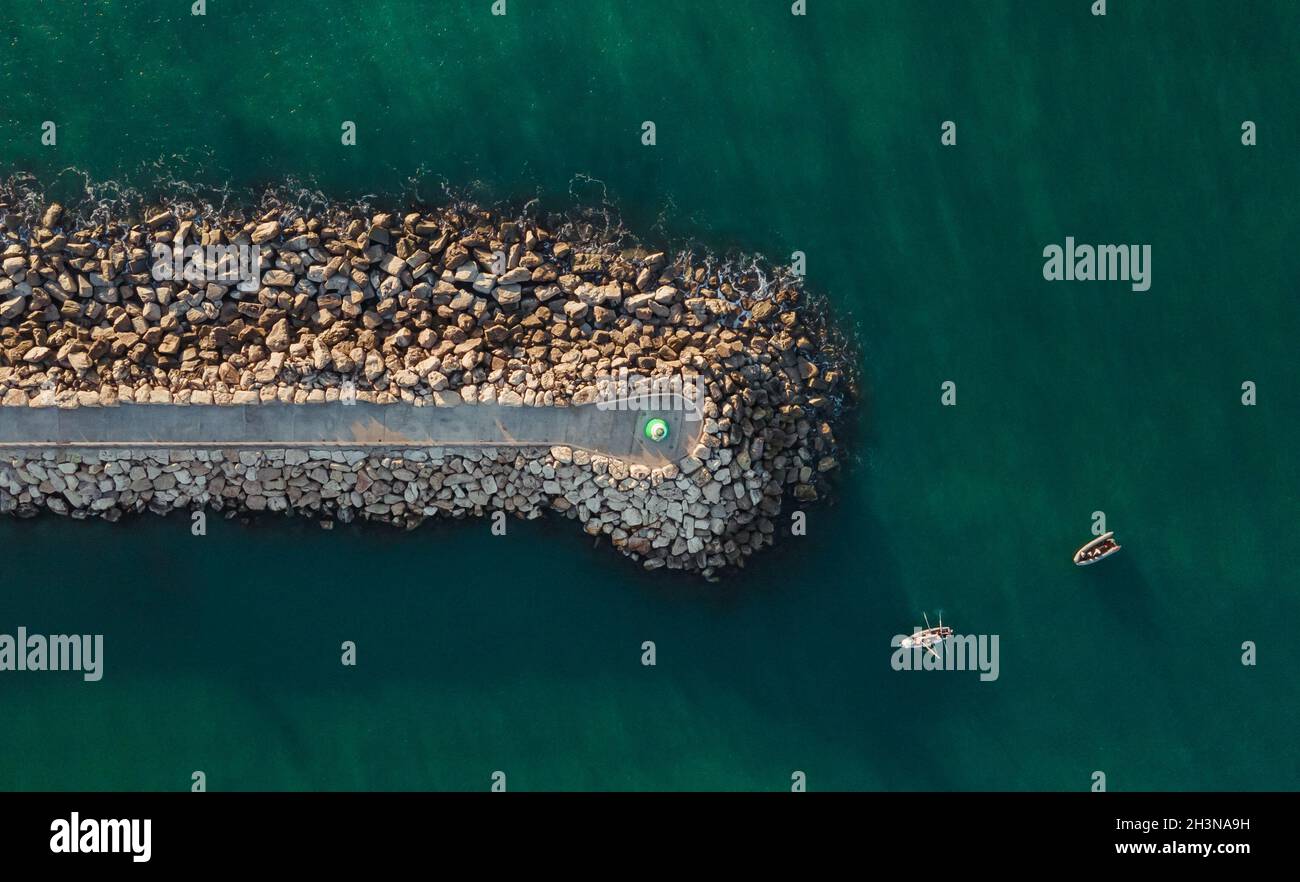 Aerial top view of a lighthouse on a geological formation in the sea ...