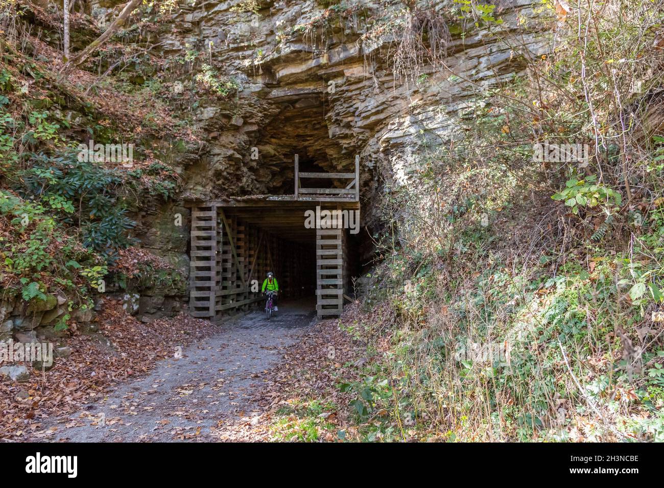 Martinton, West Virginia - John West, 75, rides out of the Droop Mountain Tunnel on the Greenbrier River Trail. The 78-mile rail trail runs along the Stock Photo