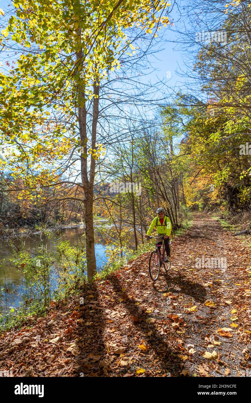 Martinton, West Virginia - John West, 75, rides his bicycle on the Greenbrier River Trail. The 78-mile rail trail runs along the Greenbrier River. Now Stock Photo