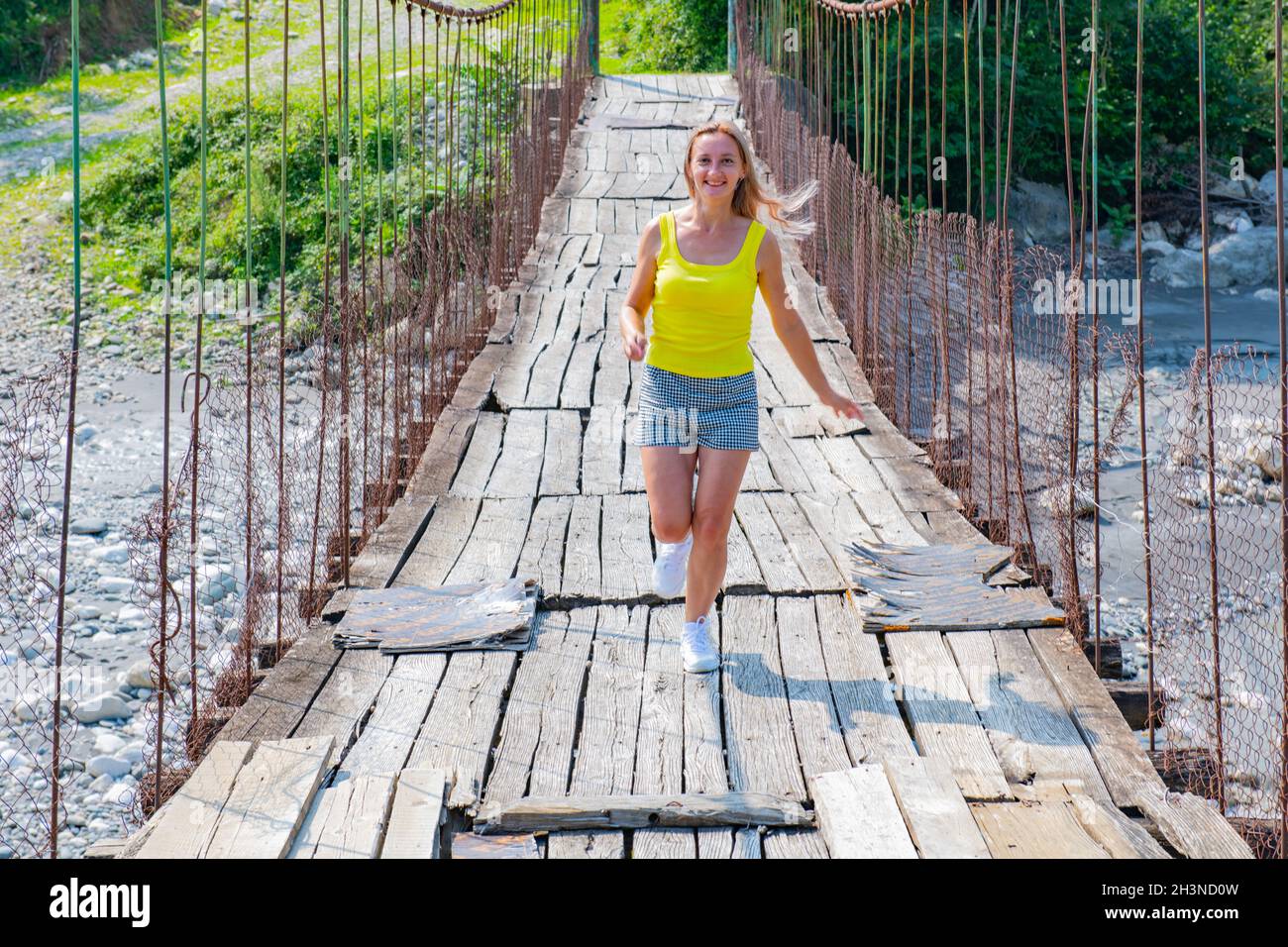 woman jumping on a suspension bridge in Stock Photo Alamy