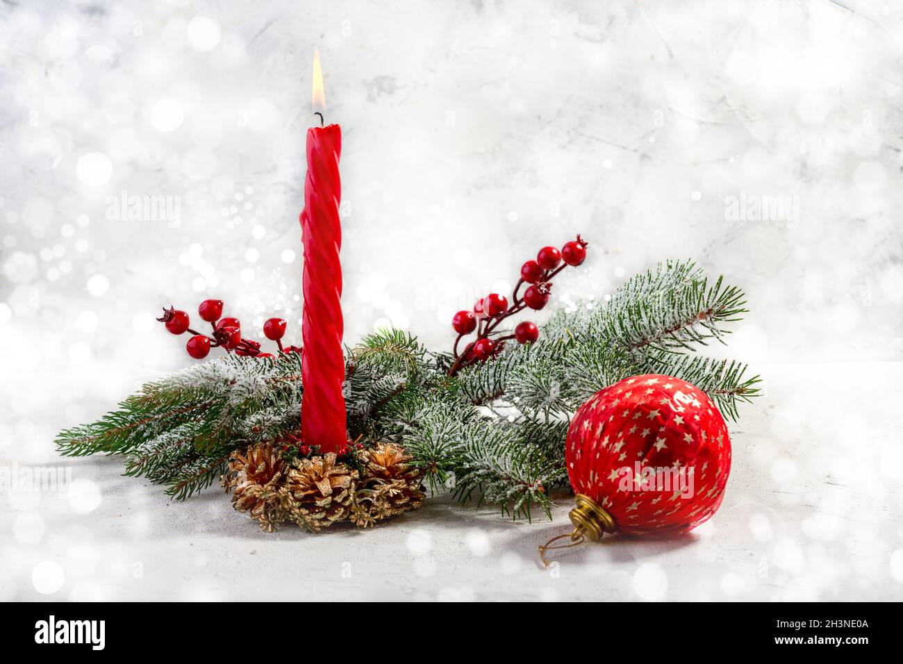 Burning red candle with snow fir branches. Christmas advent. Stock Photo
