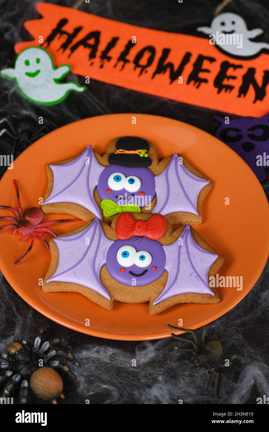 A couple (girl and boy) of funny, amusing  bat painted on honey gingerbread. Halloween food. Stock Photo