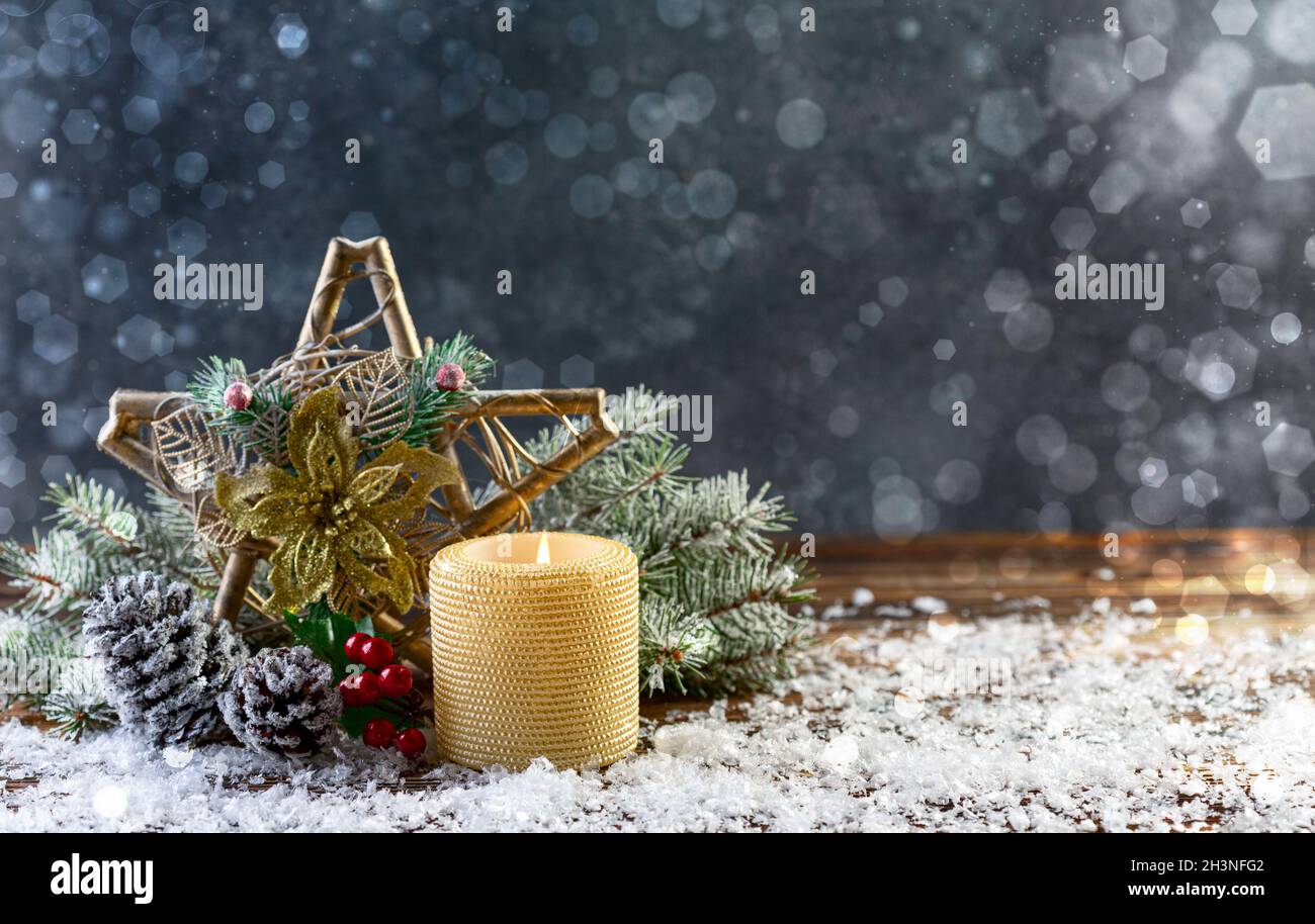 Festive composition with a Christmas star and a burning candle. Stock Photo