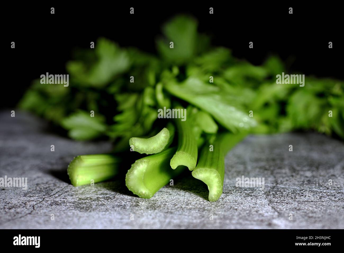 A bunch of fresh celery stalks on a concrete table. Stock Photo