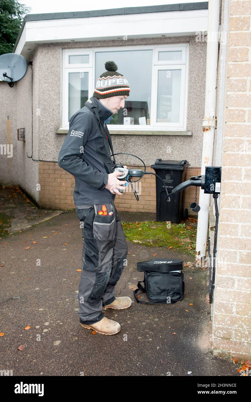 Installing an electric car home charging point on a house in Aberdeen Scotland Stock Photo