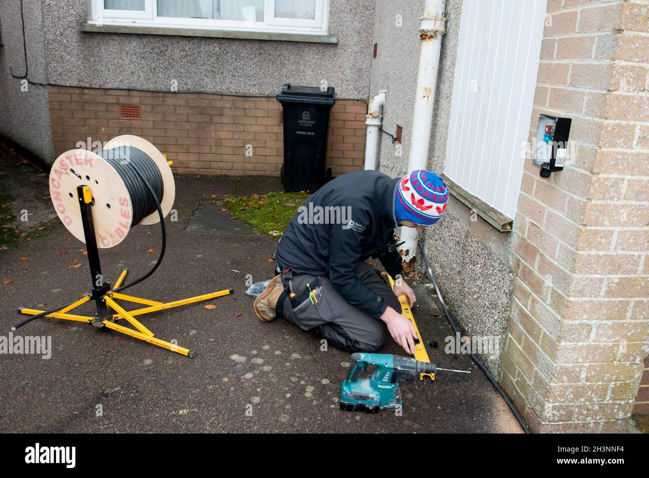 Installing an electric car home charging point on a house in Aberdeen Scotland Stock Photo