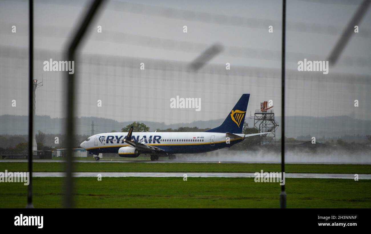 Glasgow, Scotland, UK. 29th Oct, 2021. PICTURED: A RyanAir Flight Boeing 737-800 leaving a trail of water, spray and cloud on the runway behind the departing aircraft taking off on a wet runway. Glasgow Airport seen 2 days before the start of the COP26 Climate Change Conference. The airport has hired in a private security company where the public can see security people stationed at every gate in high viz, along with Royal Air Force helicopters stationed for use at the climate summit along with flights arriving and departing on a wet and windy afternoon. Credit: Colin Fisher/Alamy Live News Stock Photo
