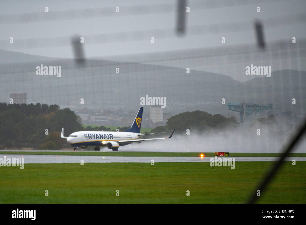 Glasgow, Scotland, UK. 29th Oct, 2021. PICTURED: A RyanAir Flight Boeing 737-800 leaving a trail of water, spray and cloud on the runway behind the departing aircraft taking off on a wet runway. Glasgow Airport seen 2 days before the start of the COP26 Climate Change Conference. The airport has hired in a private security company where the public can see security people stationed at every gate in high viz, along with Royal Air Force helicopters stationed for use at the climate summit along with flights arriving and departing on a wet and windy afternoon. Credit: Colin Fisher/Alamy Live News Stock Photo