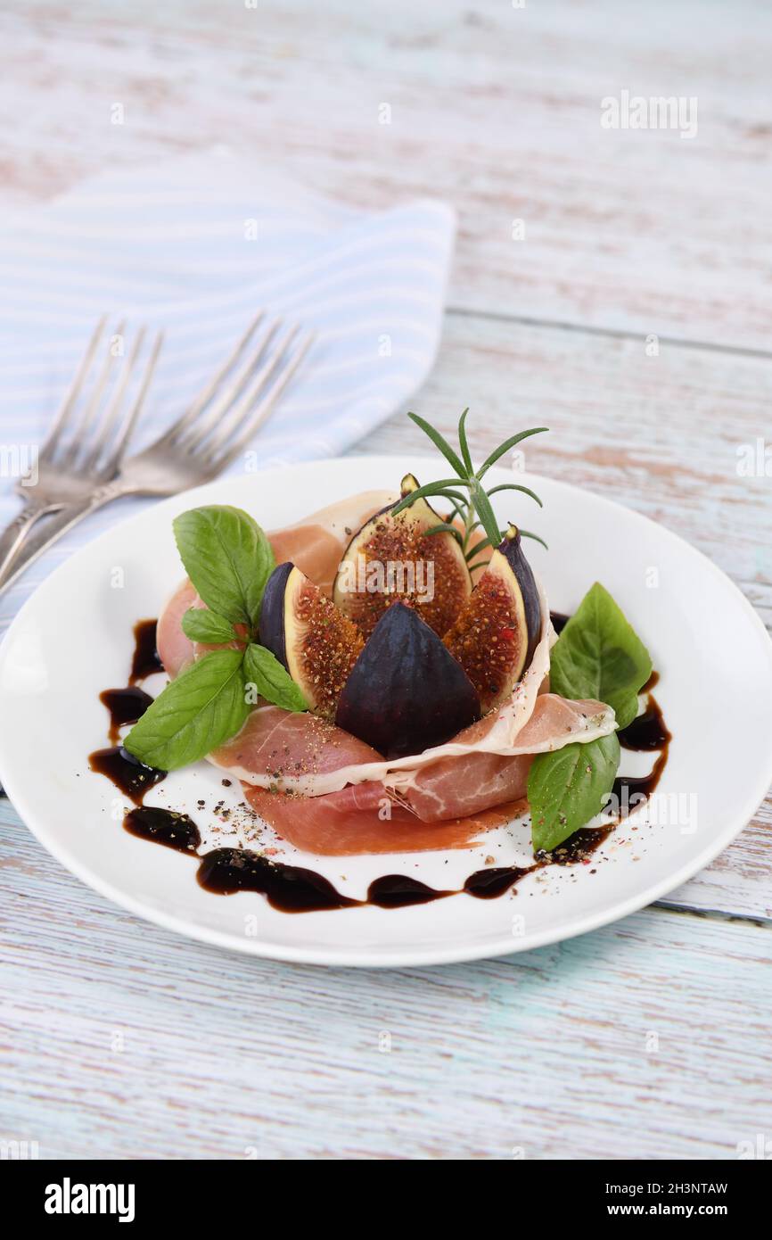 The delicate taste of prosciutto is ideally combined with the sweetness of figs. Stock Photo
