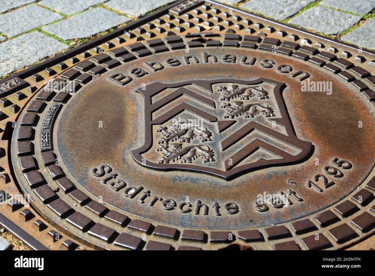 Manhole cover with coat of arms of Babenhausen Stock Photo
