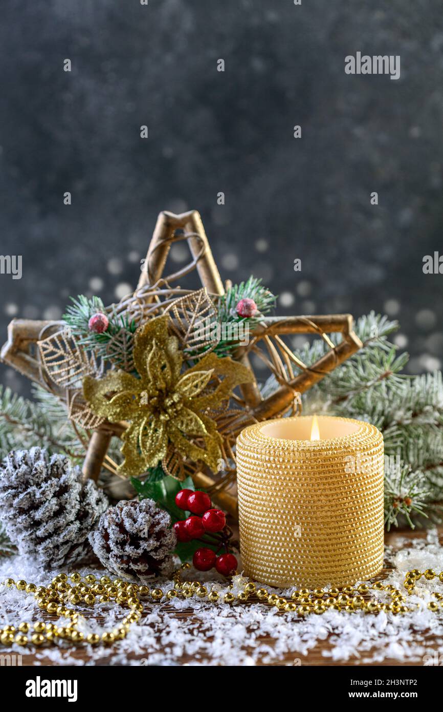 Festive composition with a Christmas star and a burning candle. Stock Photo