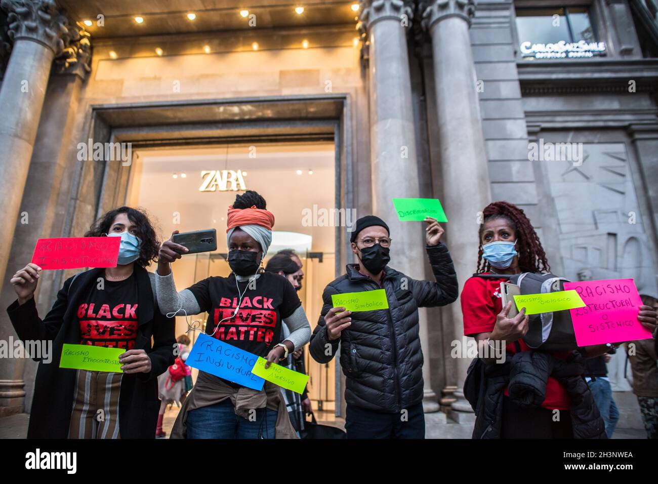 Protesters holding placards expressing their opinion, during the  demonstration.A group of Brazilian activists in Barcelona have held a  demonstration inside and outside the main Spanish clothing store, Zara,  escalated by various cases