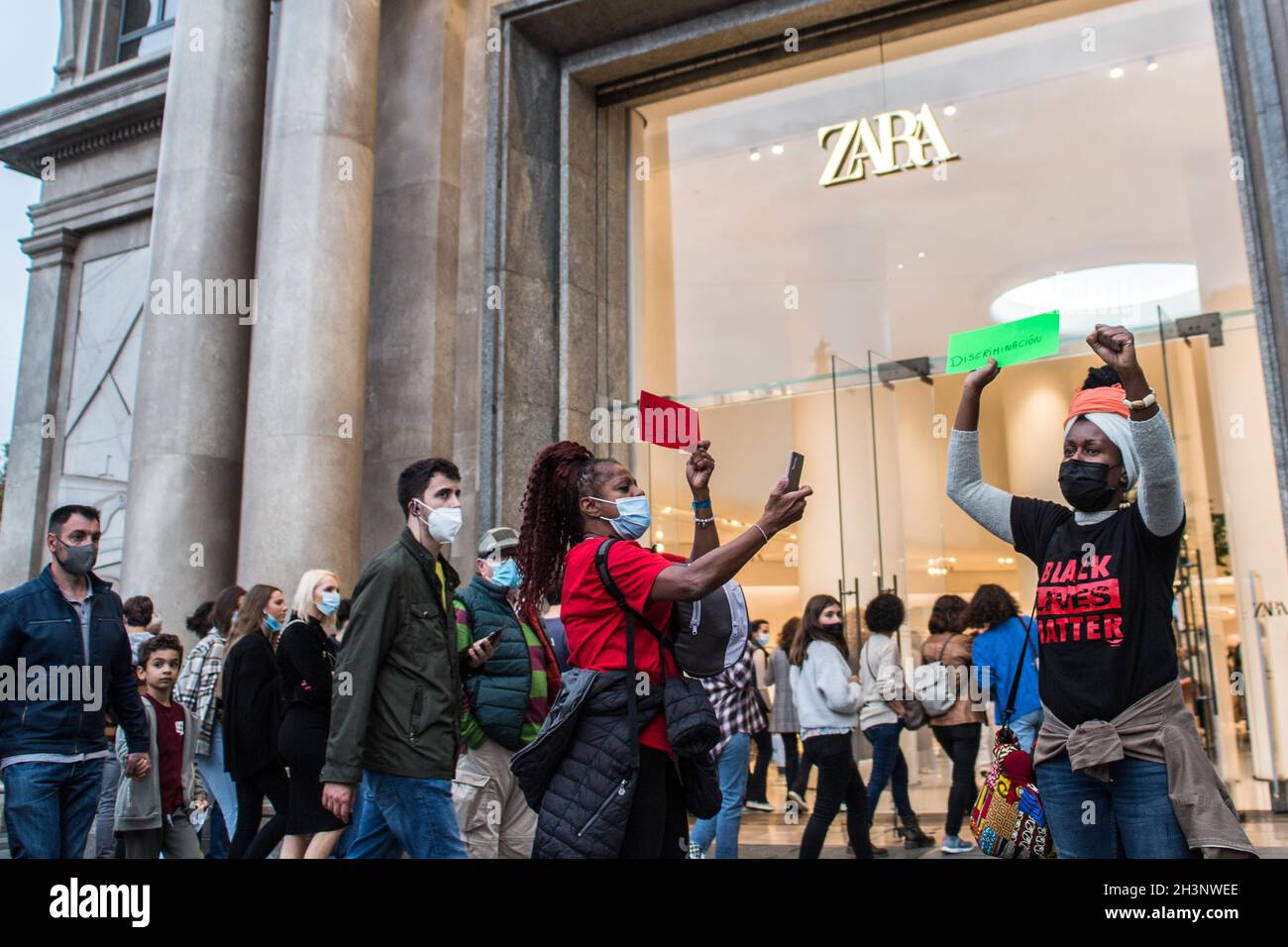 Protesters shouting slogans as one makes a gesture, during the  demonstration.A group of Brazilian activists in Barcelona have held a  demonstration inside and outside the main Spanish clothing store, Zara,  escalated by