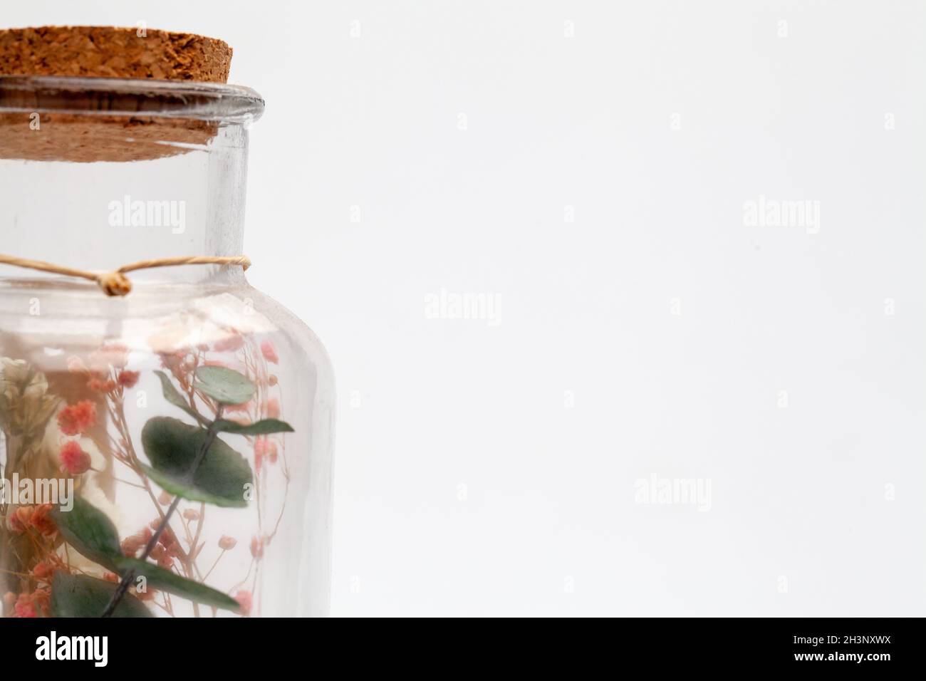Bouquet of dry flowers and potpourri in a glass jar on a white table Stock Photo