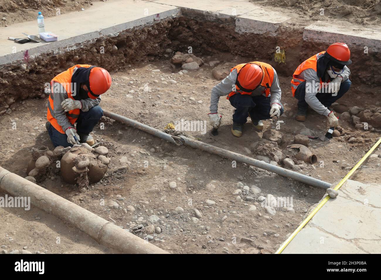 Archeologists work at a site where artifacts and human remains dating back to pre-Hispanic times were found underneath a street during an infrastructure project, in Lima, Peru October 29, 2021. REUTERS/Sebastian Castaneda Stock Photo
