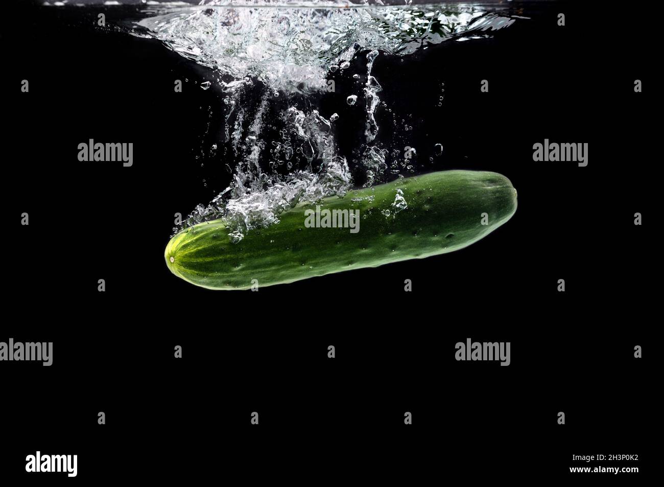 Green bio cucumber sinking under water against black background Stock ...