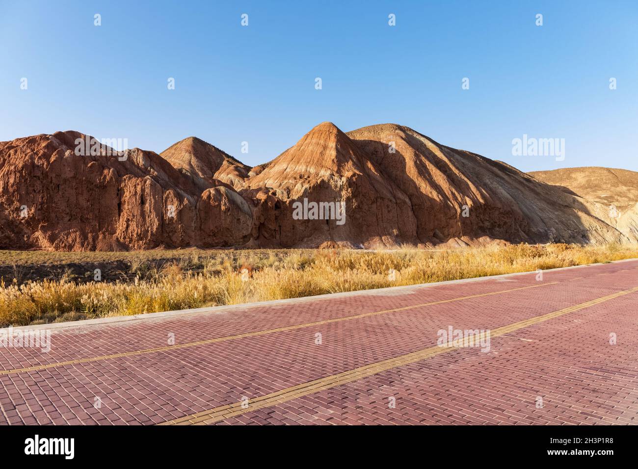 Brick road with beautiful hilly landscape at dusk Stock Photo