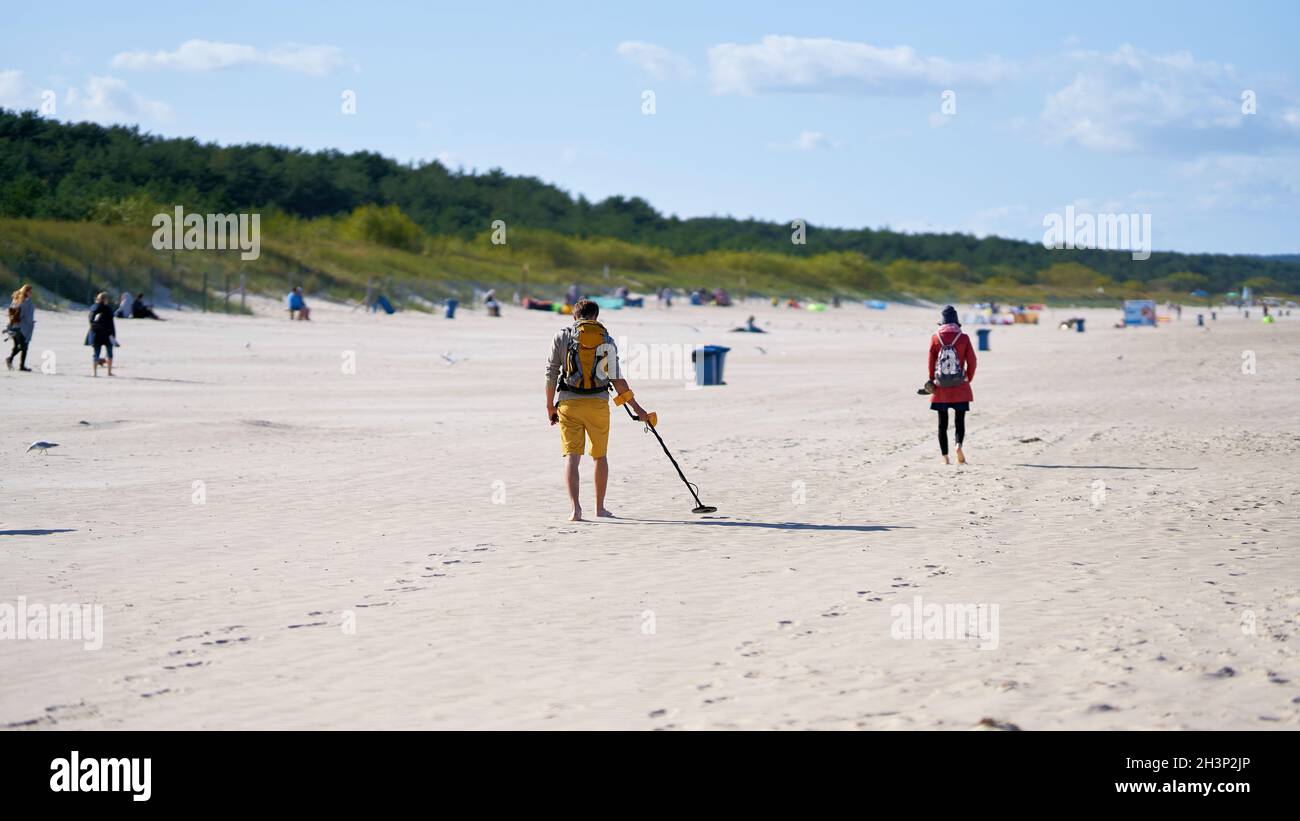 Treasure hunter with metal detector on the beach of Swinoujscie on the