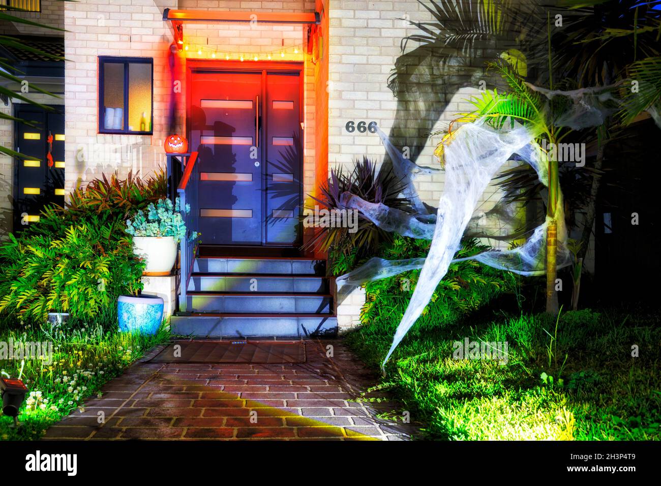 Decoration of residential house in Sydney city suburb for Halloween fun holiday with usual creepy characters at night with lights. Stock Photo