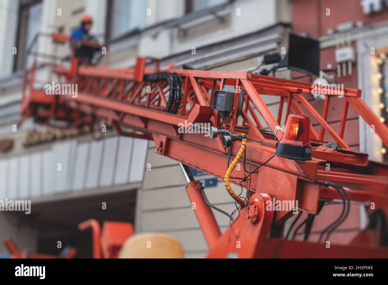 Aerial work platform vehicle during facade decoration, orange