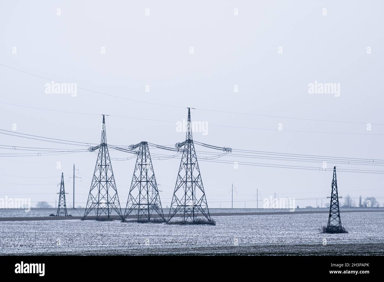 Electric poles for distribution of high voltage currents. Aerial power lines. Stock Photo