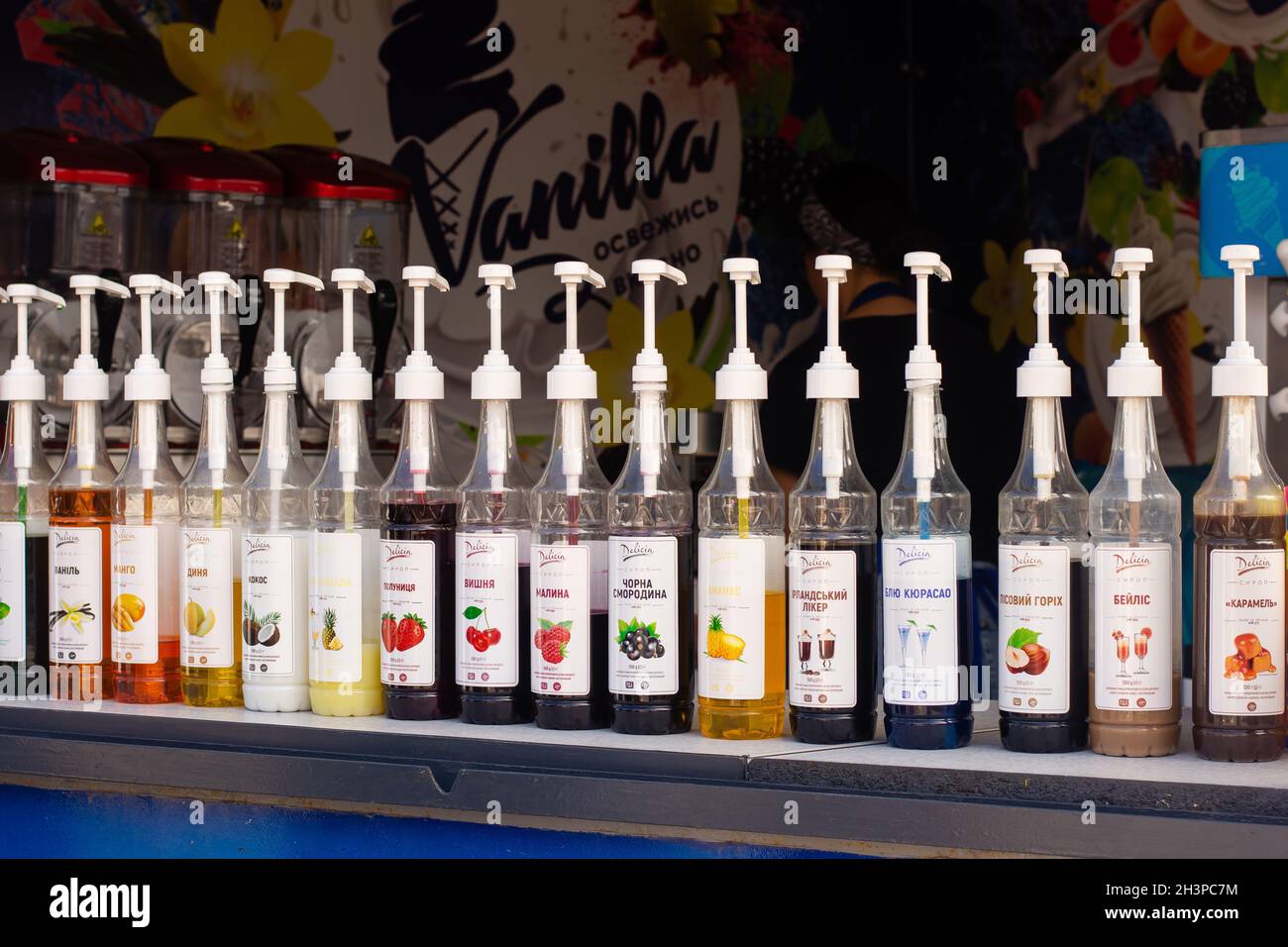 Various sweet syrups in plastic bottles with dispensers at an ice cream