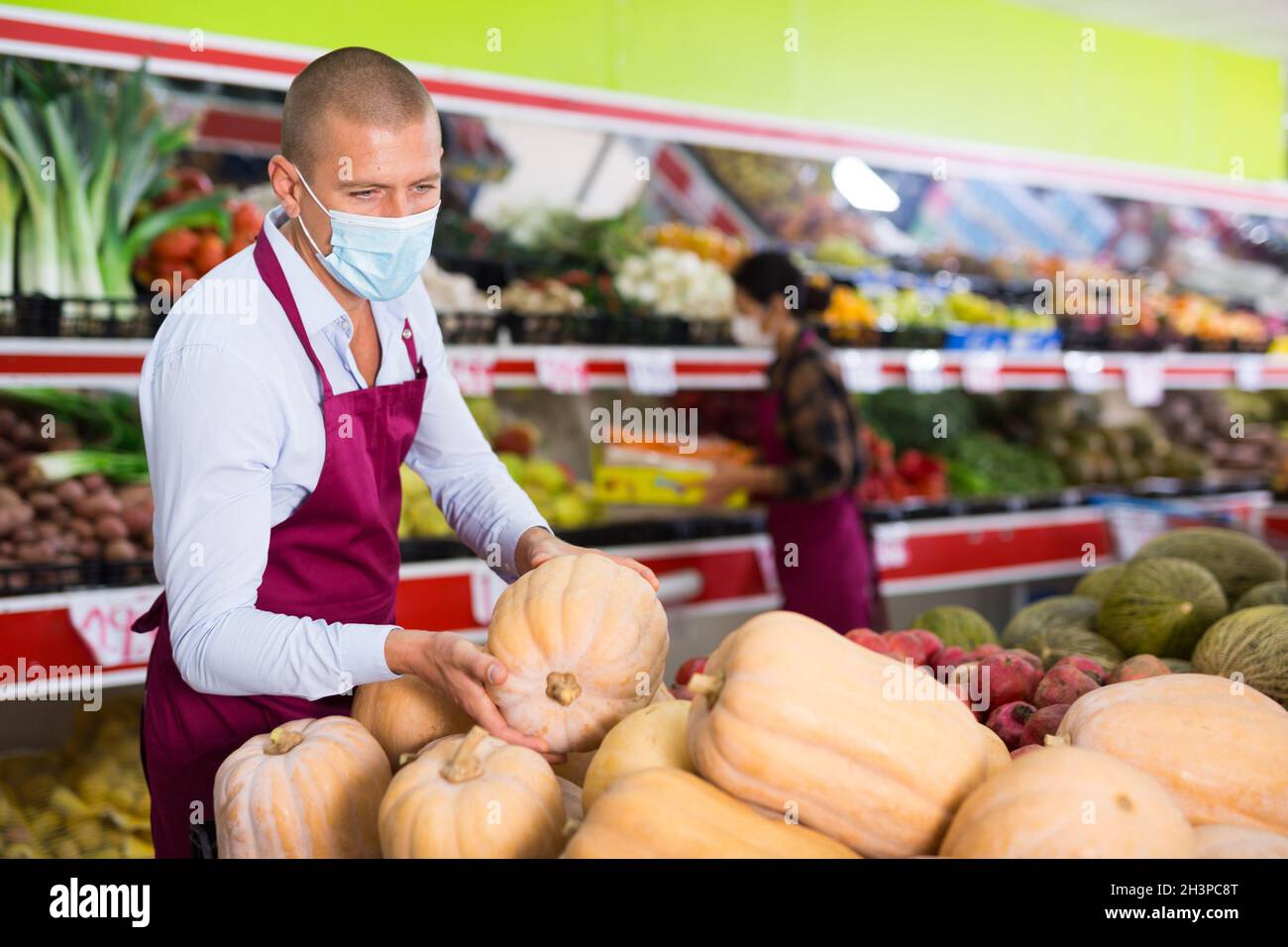 Supermarket workers in masks in salesroom Stock Photo