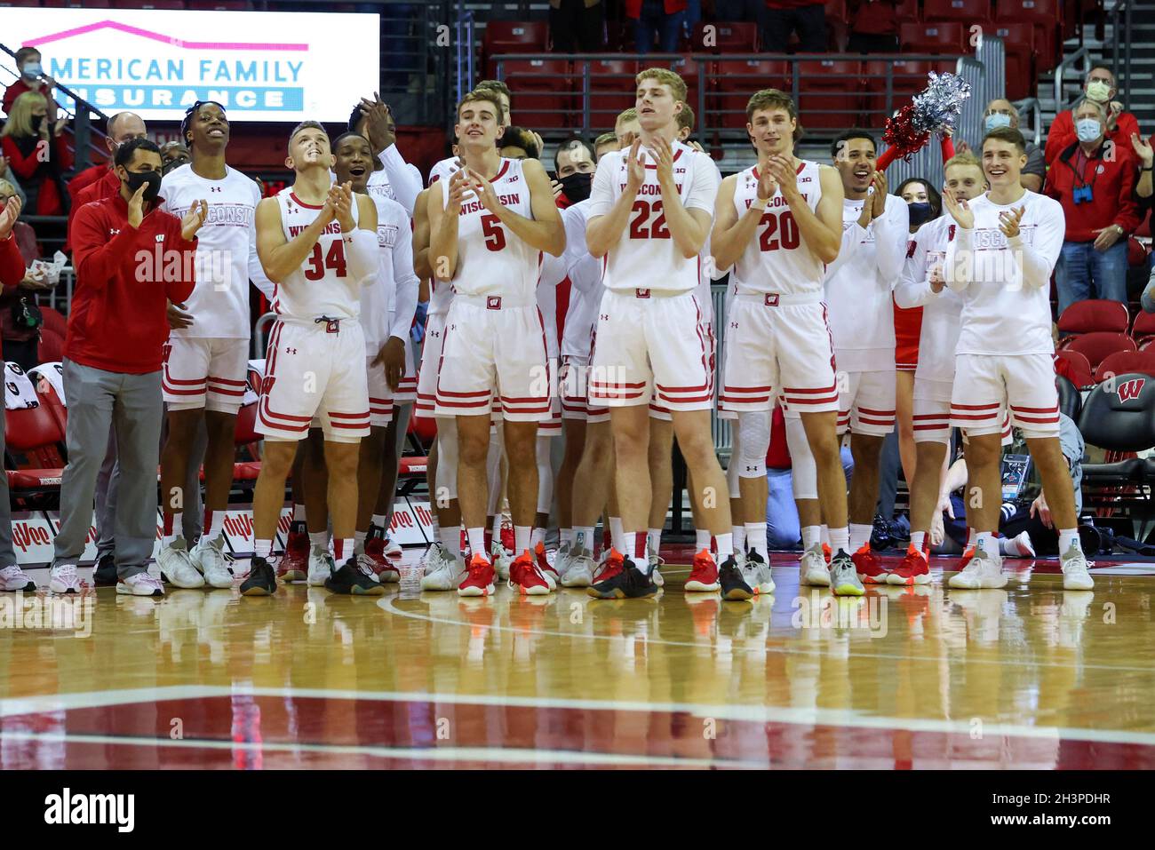 Madison, WI, USA. 29th Oct, 2021. Wisconsin Badgers guard Brad Davison (34), forward Tyler Wahl (5), forward Steven Crowl (22), forward Ben Carlson (20), and the rest of the team cheer on the Coaches for Cancer to show appreciation to Walt McGory during the NCAA Basketball game between the UW-Whitewater Warhawks and the Wisconsin Badgers at the Kohl Center in Madison, WI. Darren Lee/CSM/Alamy Live News Stock Photo