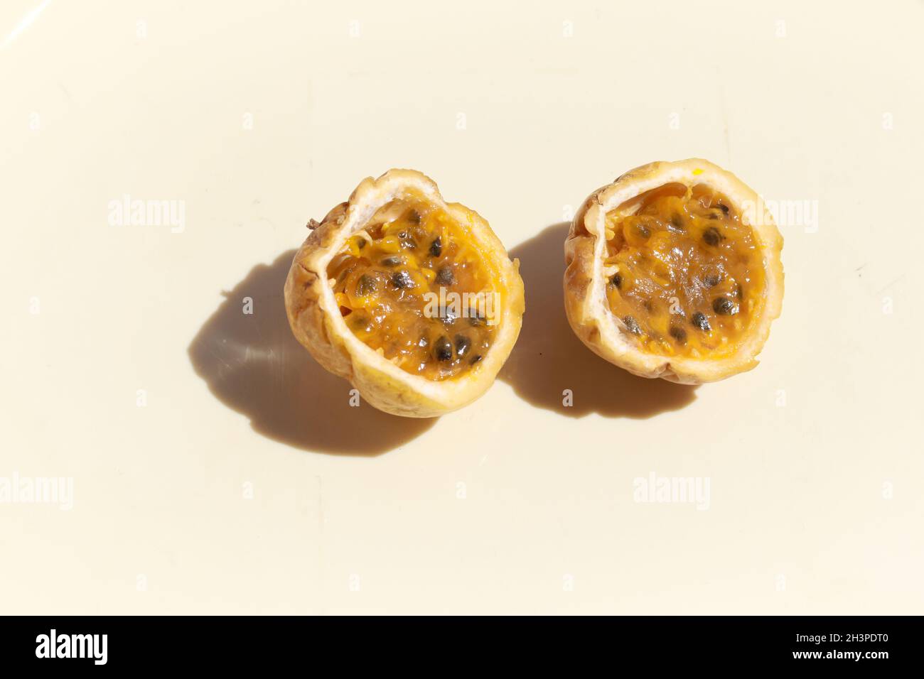 Yellow passion fruit or Passiflora edulis sliced in half against a white background Stock Photo